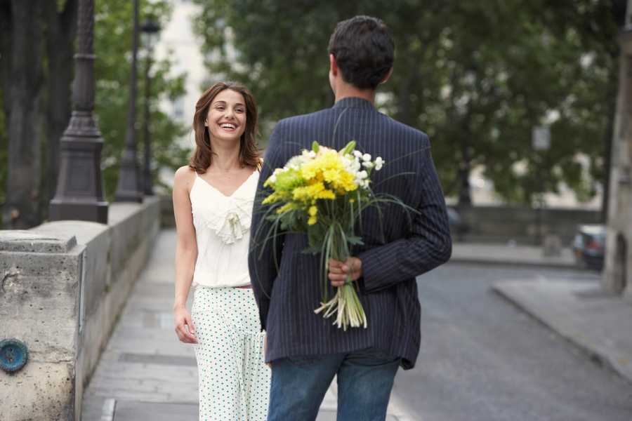 Caballero llevando flores a una chica en una cita romántica